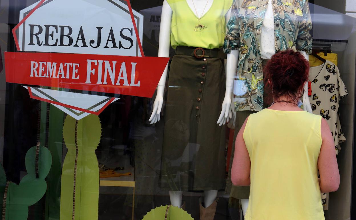 Una mujer observa el escaparate de una tienda de la calle Regalado.