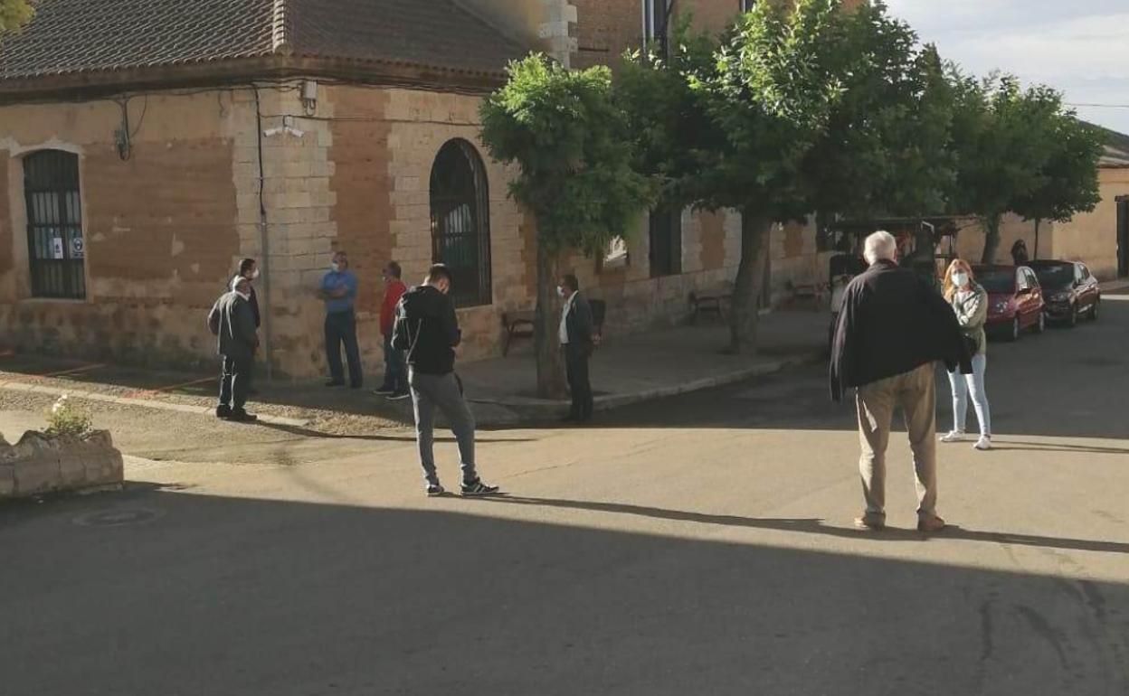 Vecinos esperan en la calle a ser llamados para someterse al PCR en el consultorio médico.