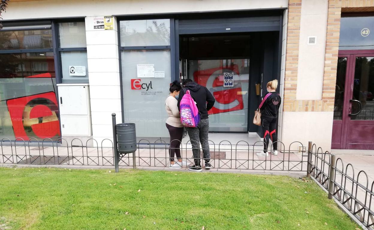 Un grupo de personas a la puerta de la oficina de empleo. 