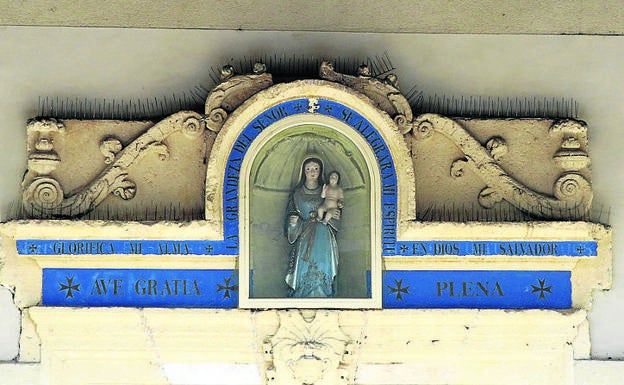 Imagen principal - Arriba, la Virgen en una hornacina; debajo, vidriera de la iglesia y fachada de la ermita.