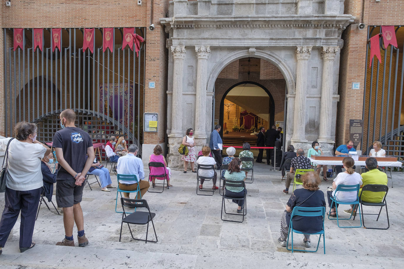 Hay sillas negras, azules y verdes, esparcidas por el empedrado suelo del acceso a la iglesia de San Lorenzo, en la calle Pedro Niño | Y allí, sentados, en la calle y con la vista en el interior del templo, un grupo de fieles sige la celebración