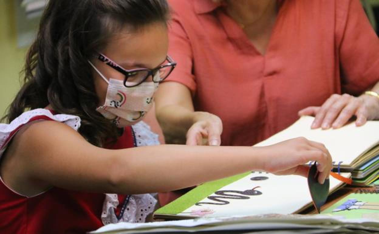 Aitana recorre las páginas de un libro. 