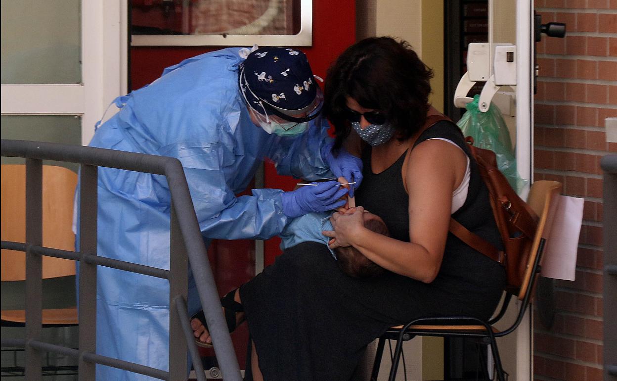 Personal sanitario toma una muestra a un bebé para una PCR en el centro Circular-Pilarica. 