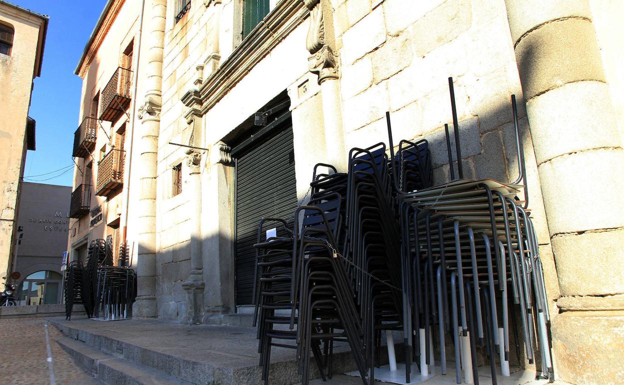 Acopio de mobiliario de una terraza junto a la fachada de un establecimiento hostelero. 