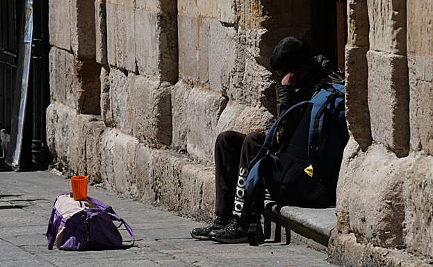 Una persona pidiendo limosna en una calle de la ciudad.