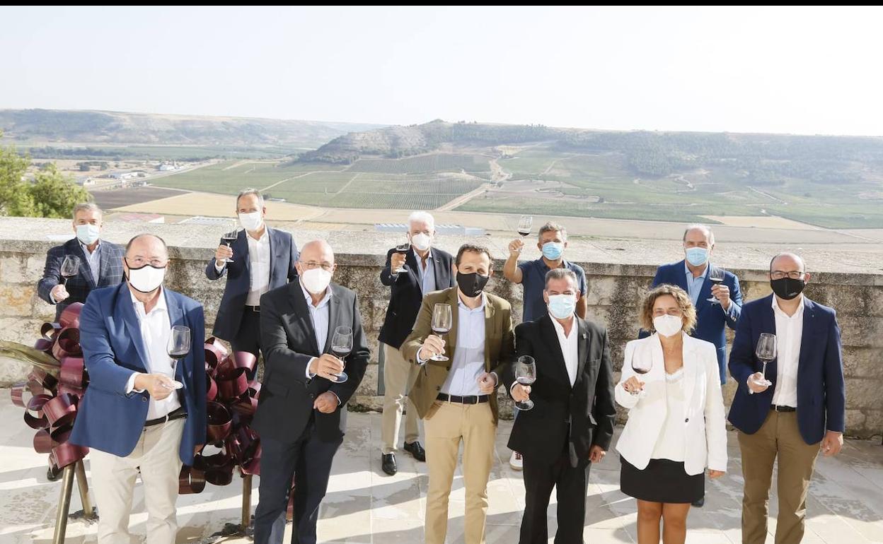 Los participantes en la jornada brindan ante el castillo de Peñafiel al inicio de la jornada. 