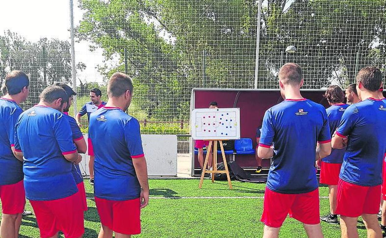 Un grupo de entrenadores de fútbol atiende en una clase práctica.