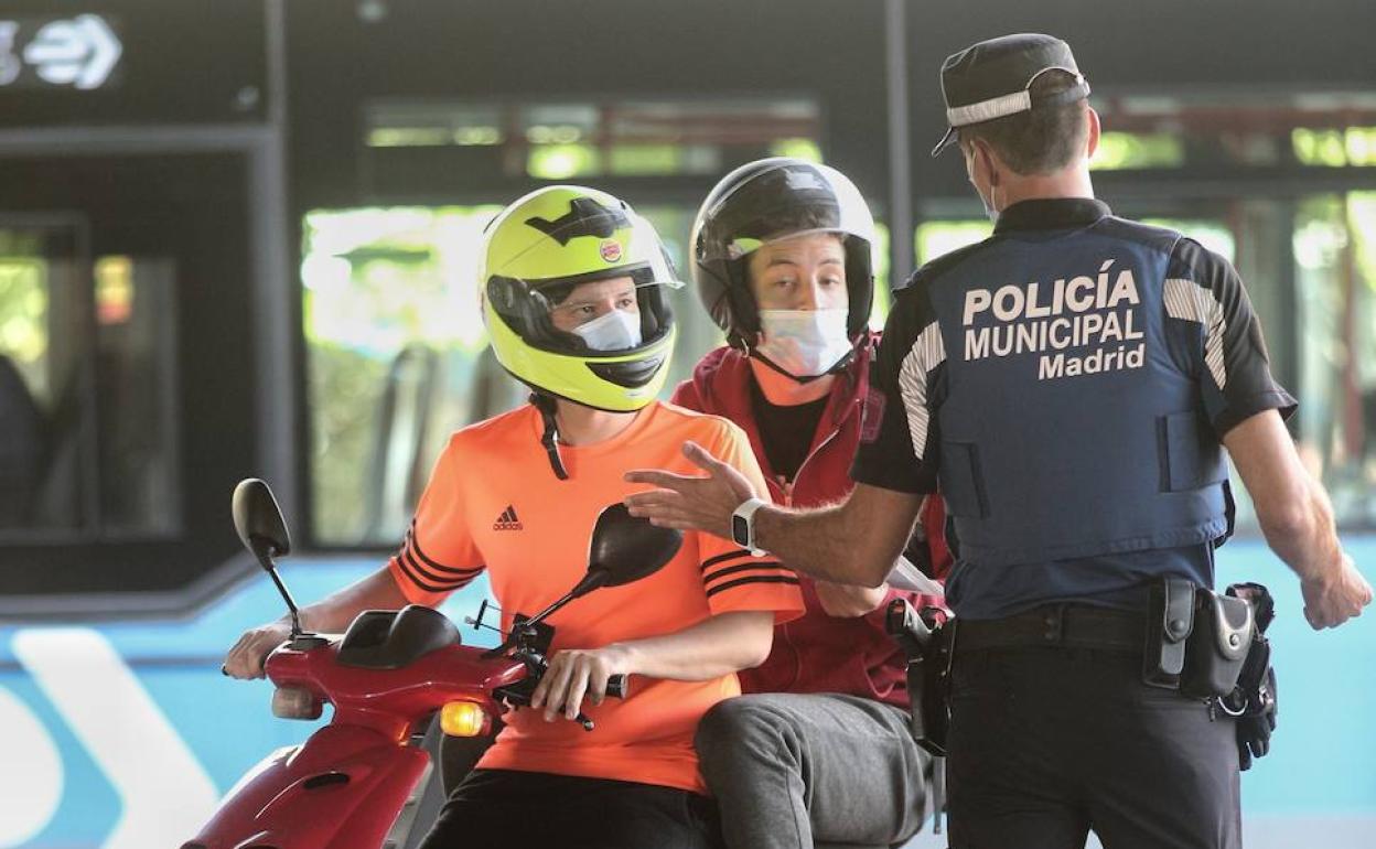 Un agente de la Policía Municipal de Madrid realiza un control de movilidad en el distrito de Puente de Vallecas, Madrid.