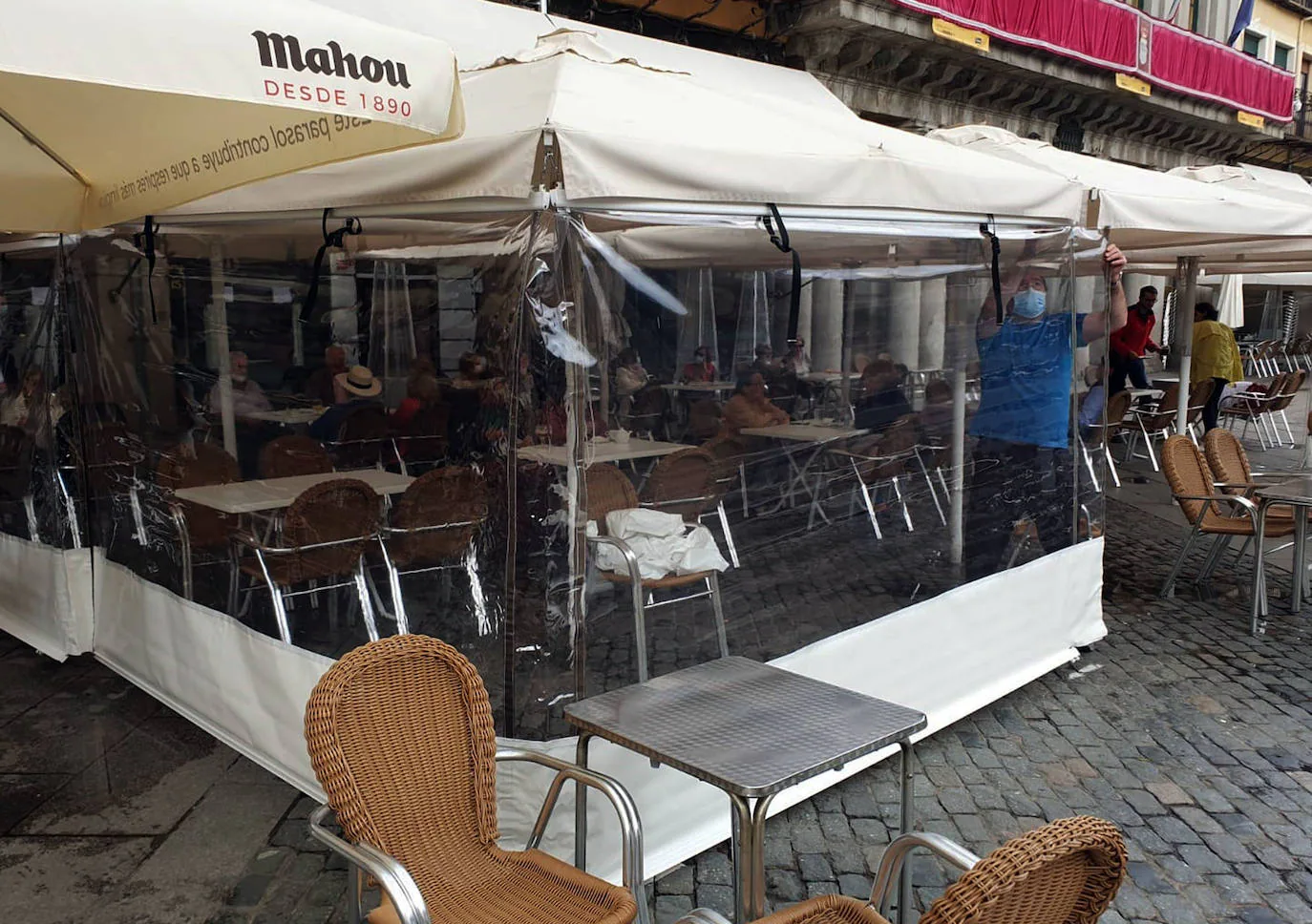 Montaje con plástico de un cortaviento en una terraza de la Plaza Mayor.