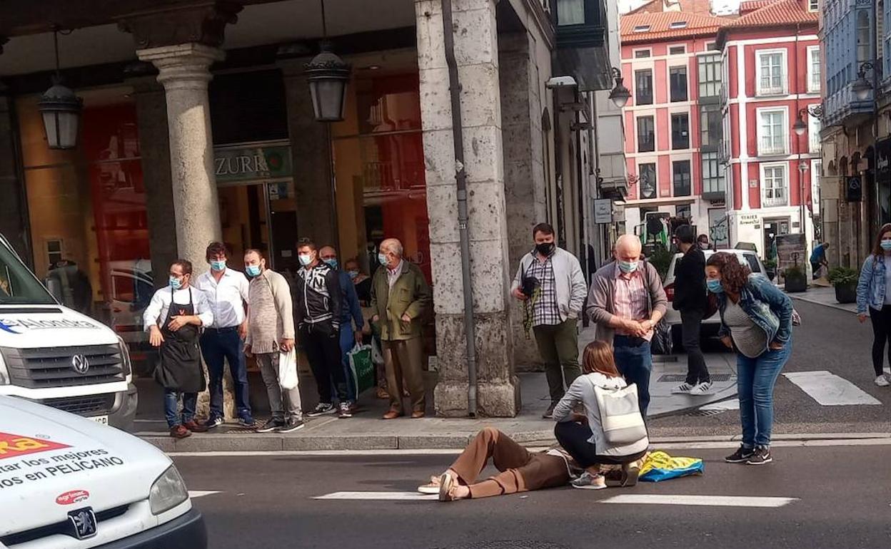 La víctima yace en el suelo, mientras recibe atención de algunos peatones en espera de la ambulancia.
