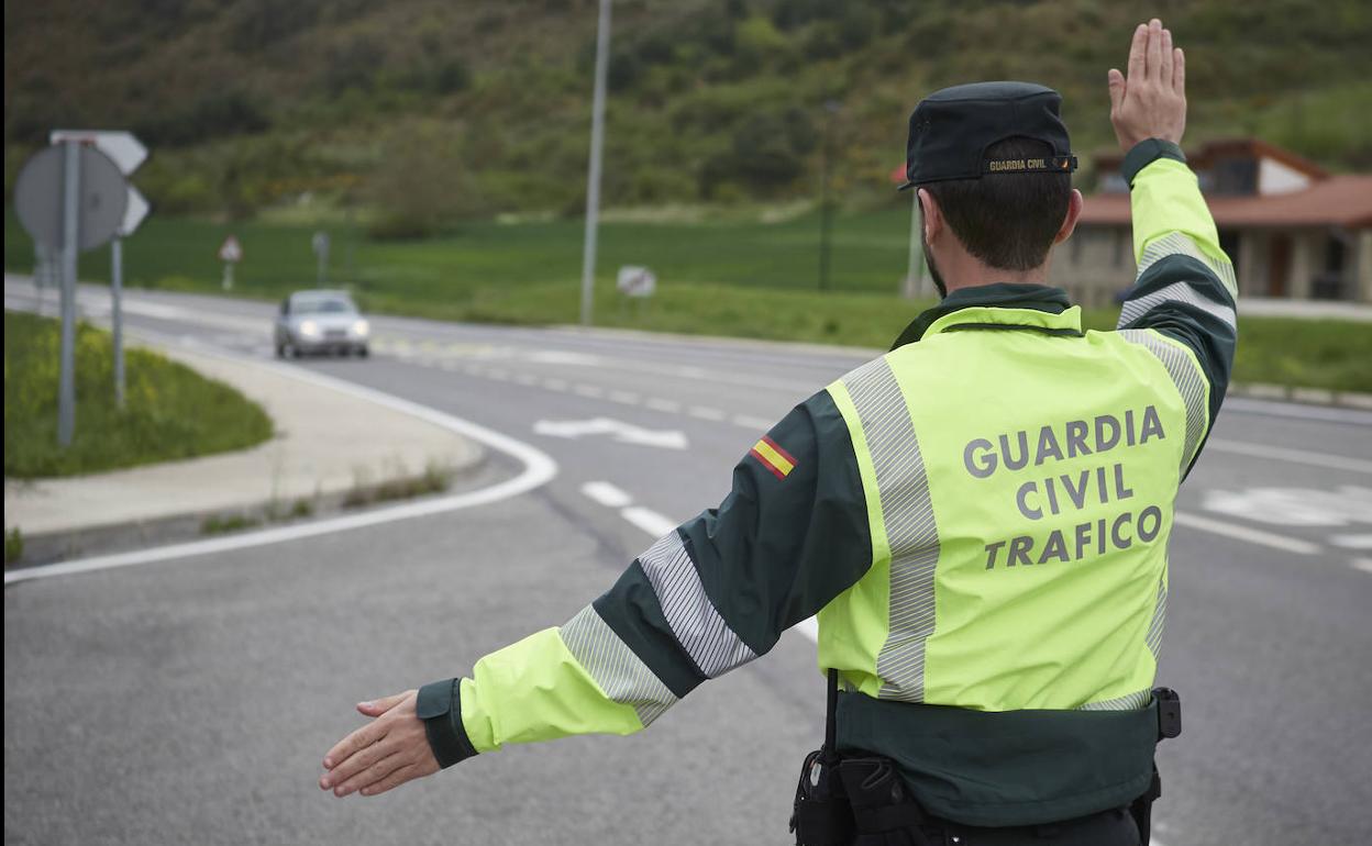 Un agente de la Guardia Civil de Tráfico manda parar a un vehículo en un control policial.