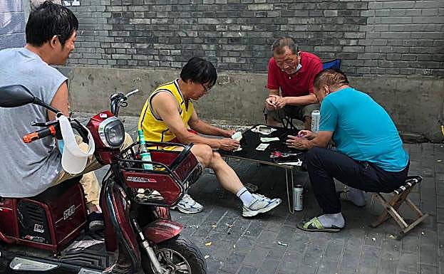 Vecinos de Pekín en la calle y sin mascarilla.