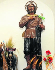 Imagen secundaria 2 - Arriba, Piedad, en uno de los laterales de la Iglesia de San Juan Evangelista; abajo, estatua de San Antonio y San Isidro.