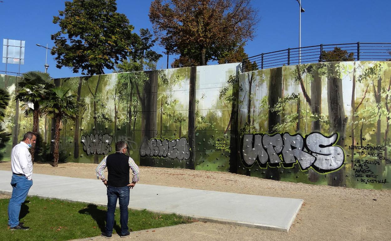 Los técnicos municipales observan los grafitis pintados sobre el mural del parque Bolaños.