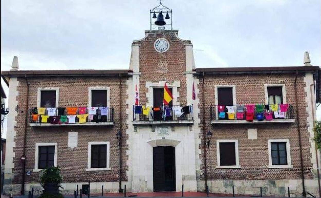 Balcón de la casa consistorial de Mojados decorado con las camisetas de las peñas.