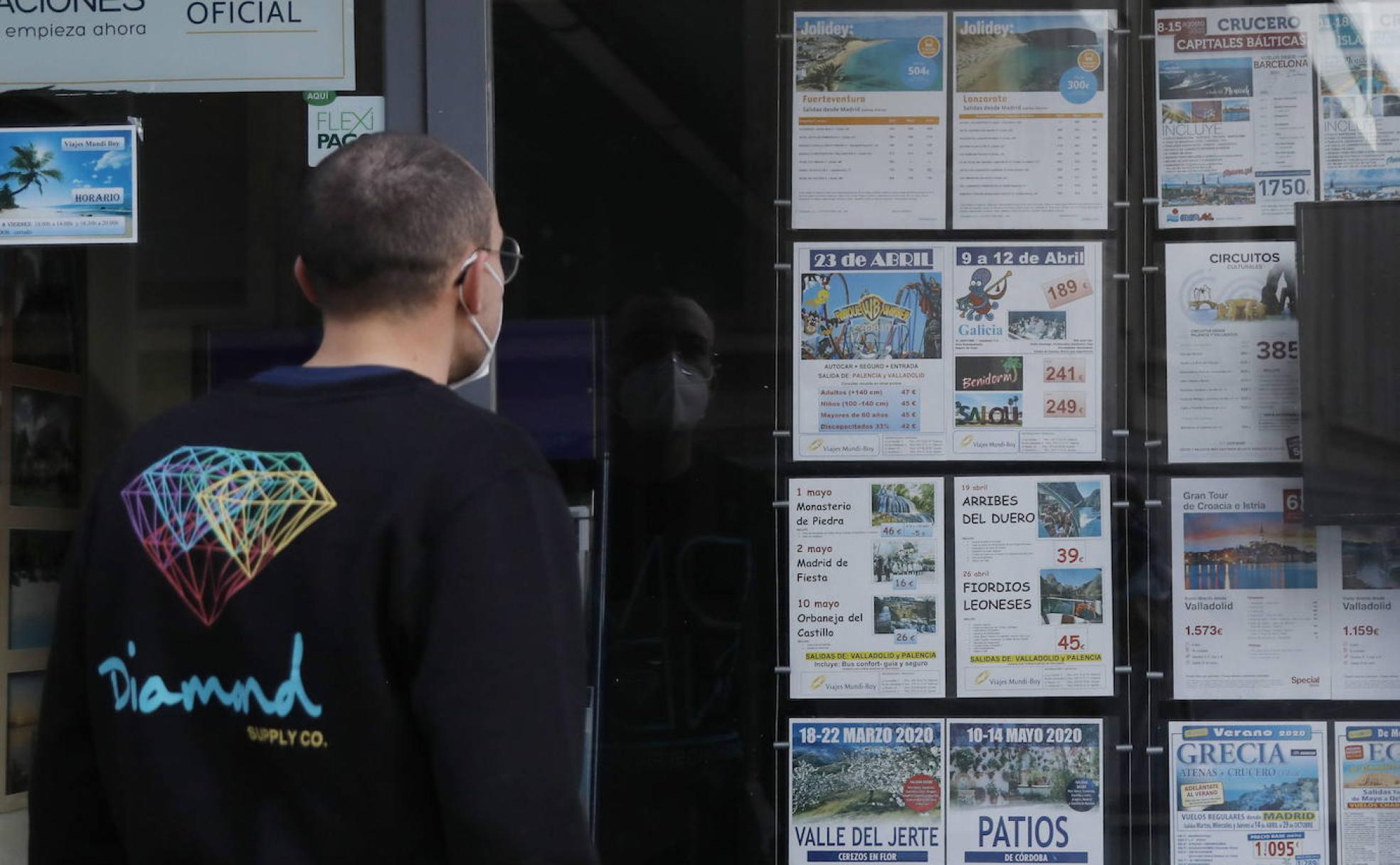 Un hombre observa los anuncios de viajes en Palencia. 