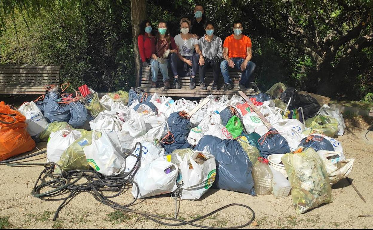 Los voluntarios muestran la basura recogida de la ribera del río en el Callejón de la Alcoholera.