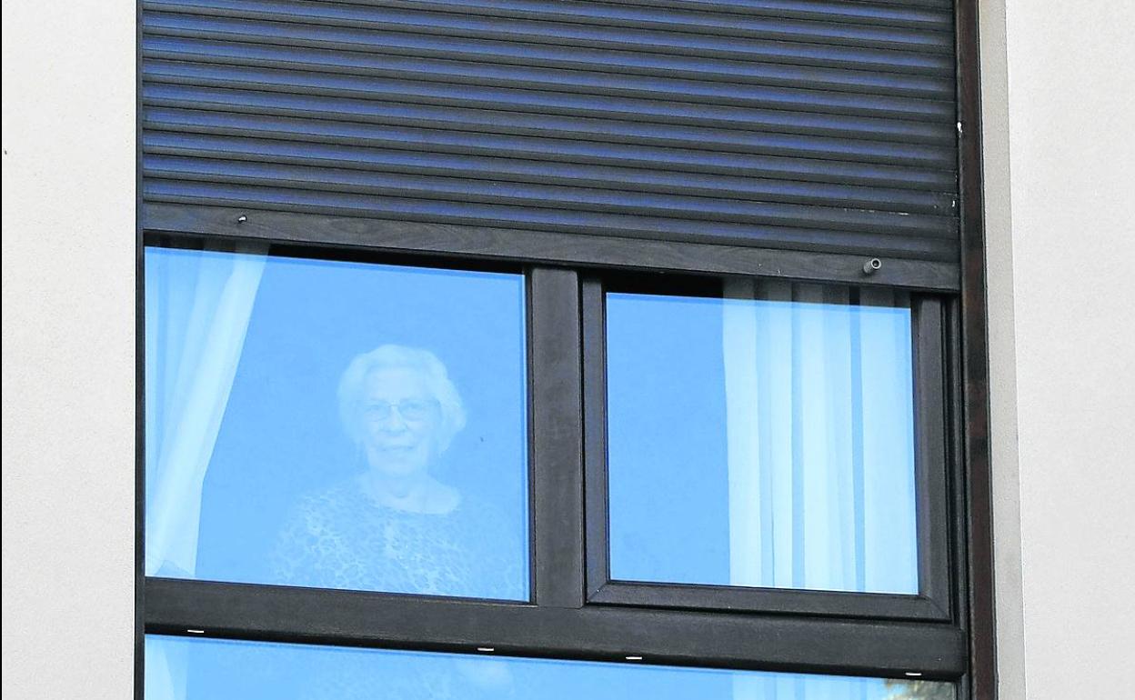 Una usuaria mira ayer por la ventana en la residencia Domingo Gómez Lesmes de Ampudia.