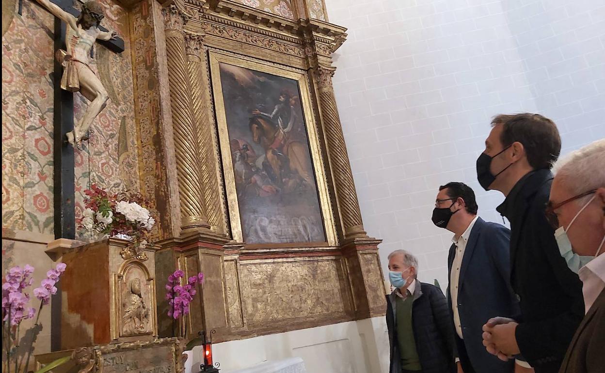 Las autoridades contemplan el retablo restaurado. 