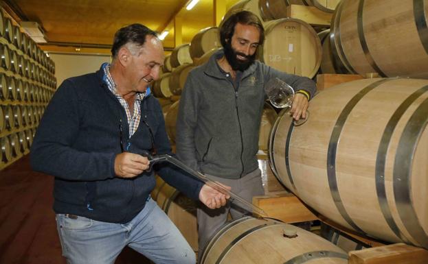 Tomás Postigo y su hijo Gabriel en la sala de barricas de la bodega de Peñafiel. 