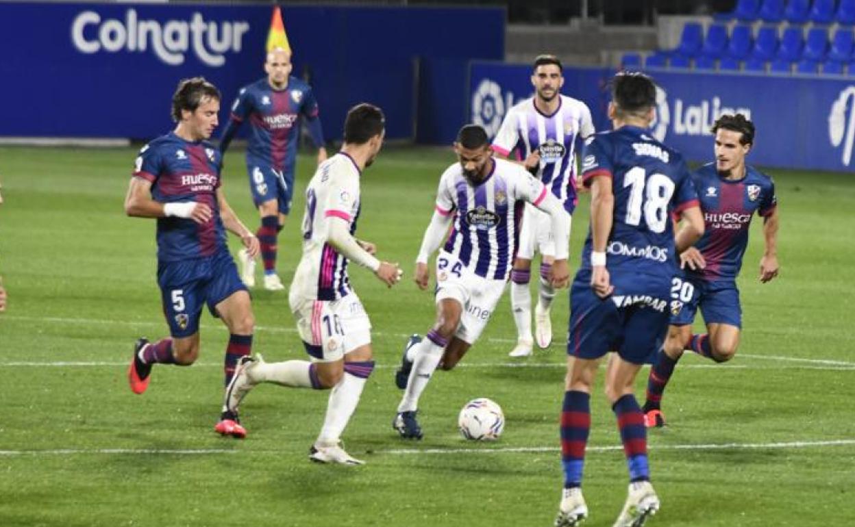 Joaquín Fernández, que entró en la segunda mitad, controla el balón rodeado por oponentes del Huesca.