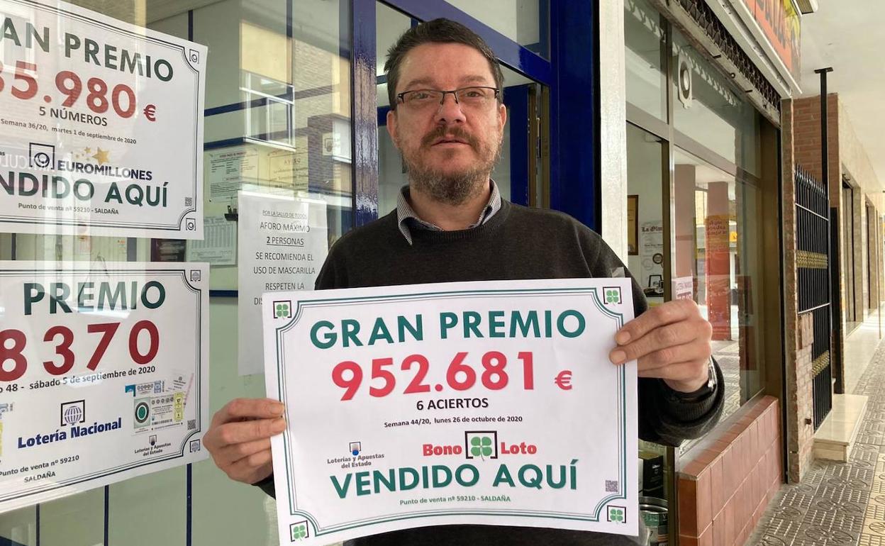Félix González, el lotero de Saldaña que selló uno de los dos boletos, con el cartel de premio.