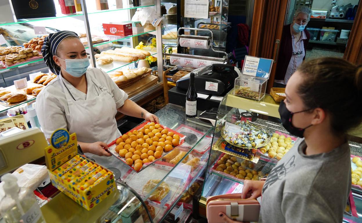 Una persona compra buñuelos en una pastelería de Jibe.