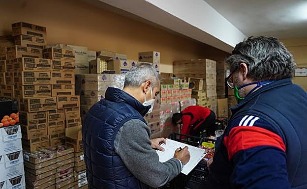 Miembros de Cajas Solidarias realizan el reparto de alimentos de ayer.