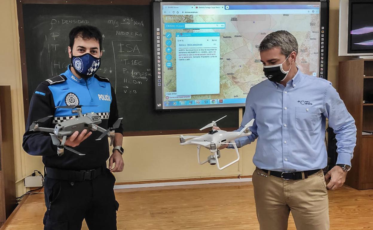 Un agente y el instructor Ander García muestran dos modelos de dron durante el curso en la Jefatura.
