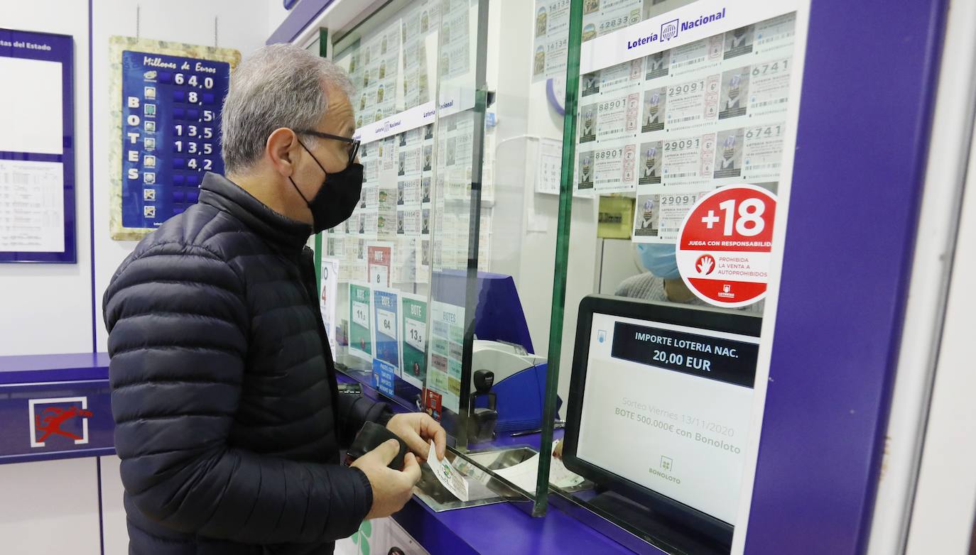 Un cliente compra un décimo de Navidad, ayer en el despacho de la calle Rizarzuela.