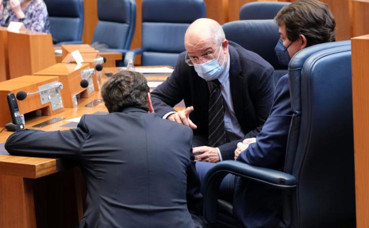 El consejero de Economía y Hacienda (de espaldas) conversa con el vicepresidente Igea y el presidente Mañueco, en el pleno de las Cortes.