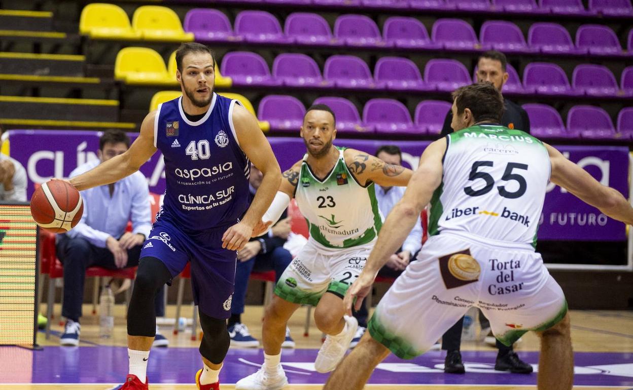 Martin Paasoja conduce el balón en el último partido ante dos jugadores de Cáceres, Jeff Xavier y Marcius. 