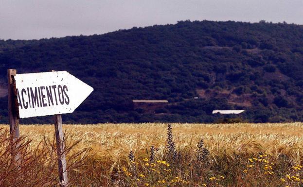 Foto angitua de un cartel que señala en la imagen hacia los yacimientos ubicados en la sierra de Atapuerca. 