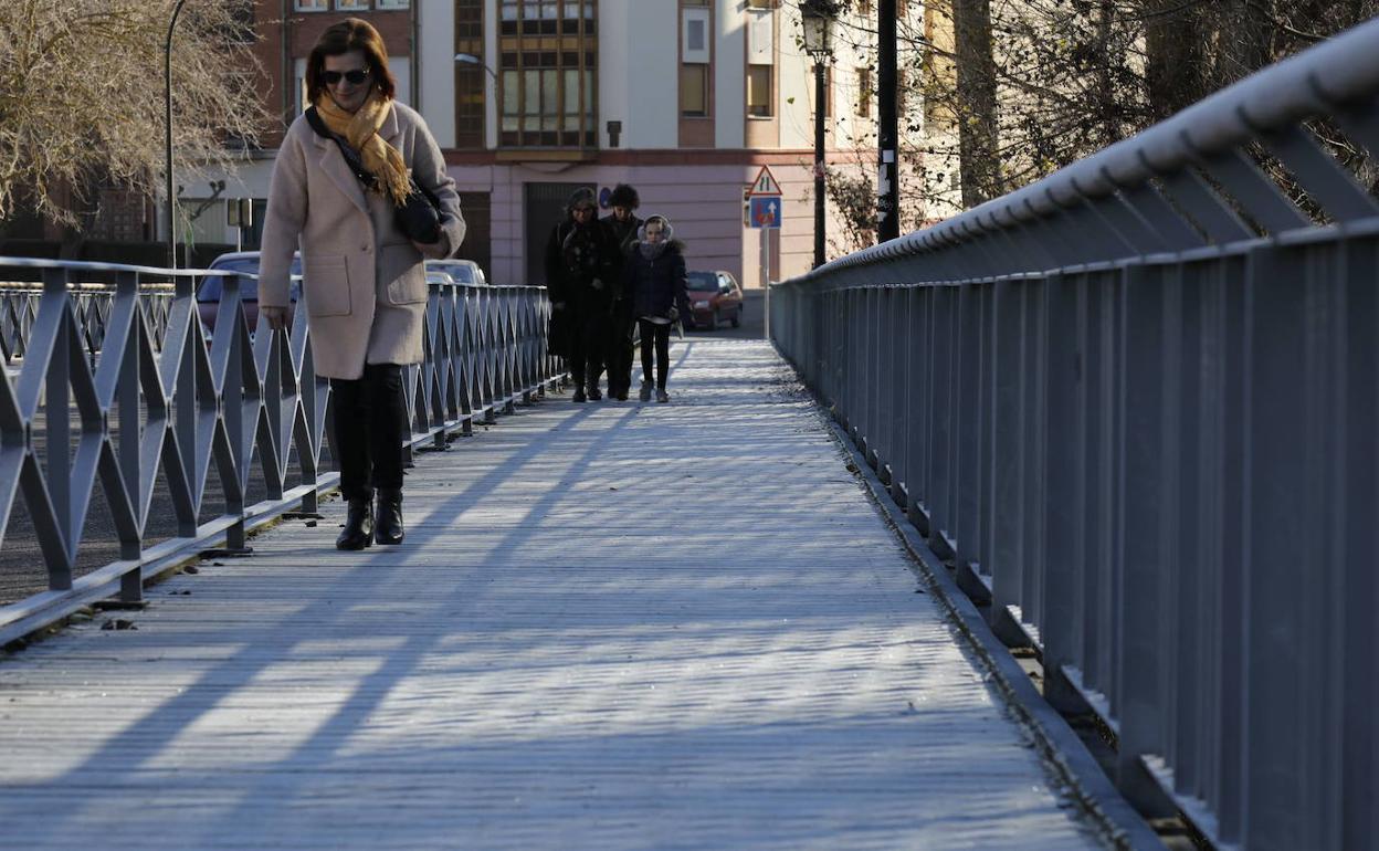 Una mujer camina por un puente de Peñafiel. 
