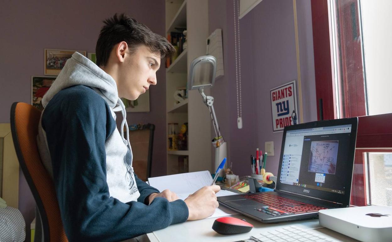 Un estudiante sigue desde su casa una clase no presencial.