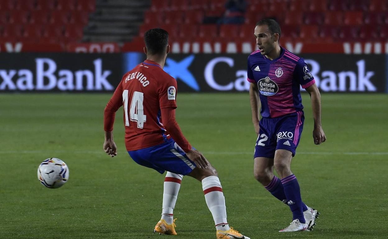 Nacho Martínez tata de superar a Fede Vico en el Granada-Real Valladolid disputado en el Nuevo Los Cármenes.