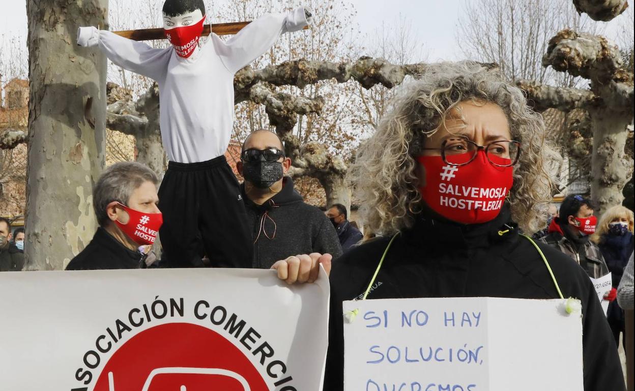 Una mujer, porta un mensaje en Venta de Baños con el muñeco crucificado detrás. 