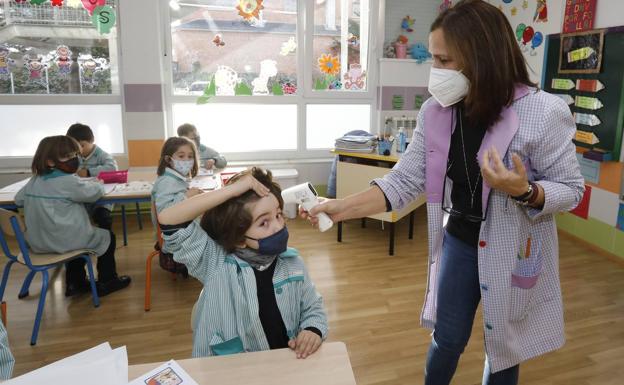 Una maestra toma la temperatura a un niño en el Colegio Santa Rita. 