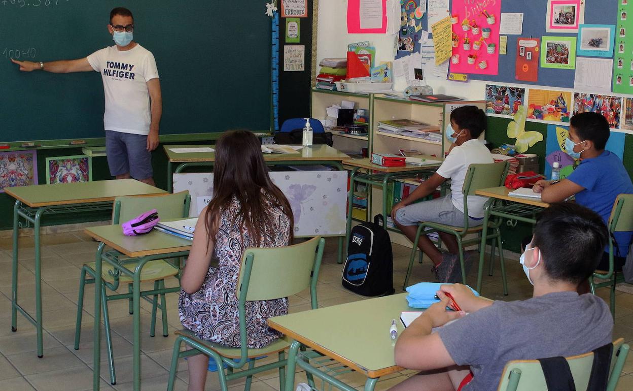 Un profesor explica la materia a sus alumnos en un colegio de Segovia. 