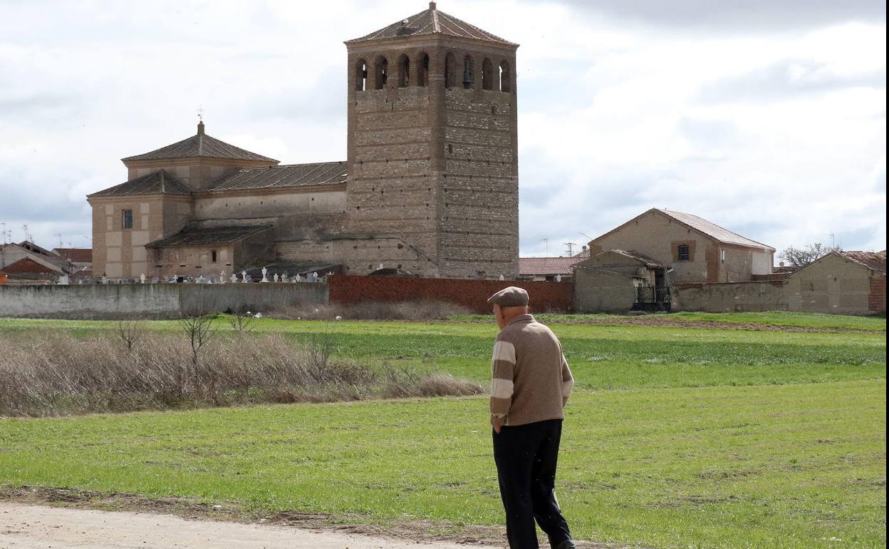 Un hombre pasea a las afueras de un pueblo de Segovia. 