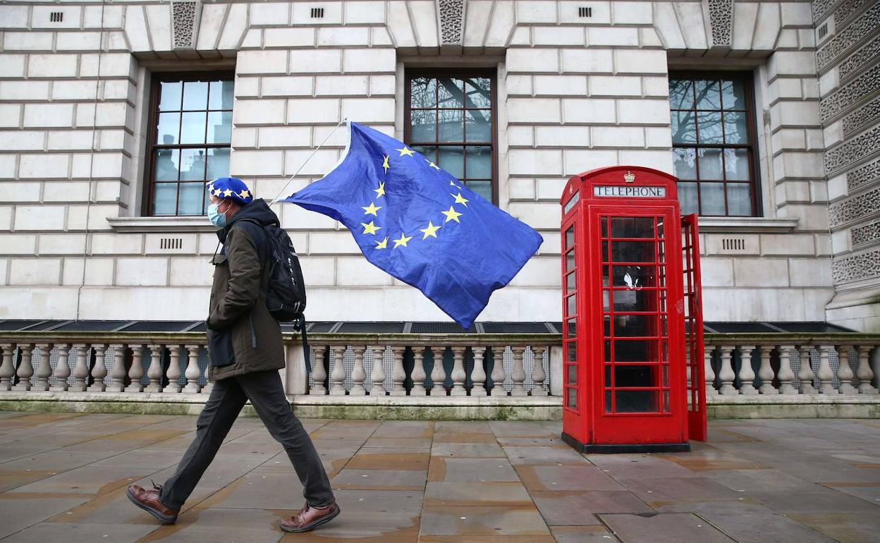 Un hombre se pasea por la City londinense con una bandera de la UE.