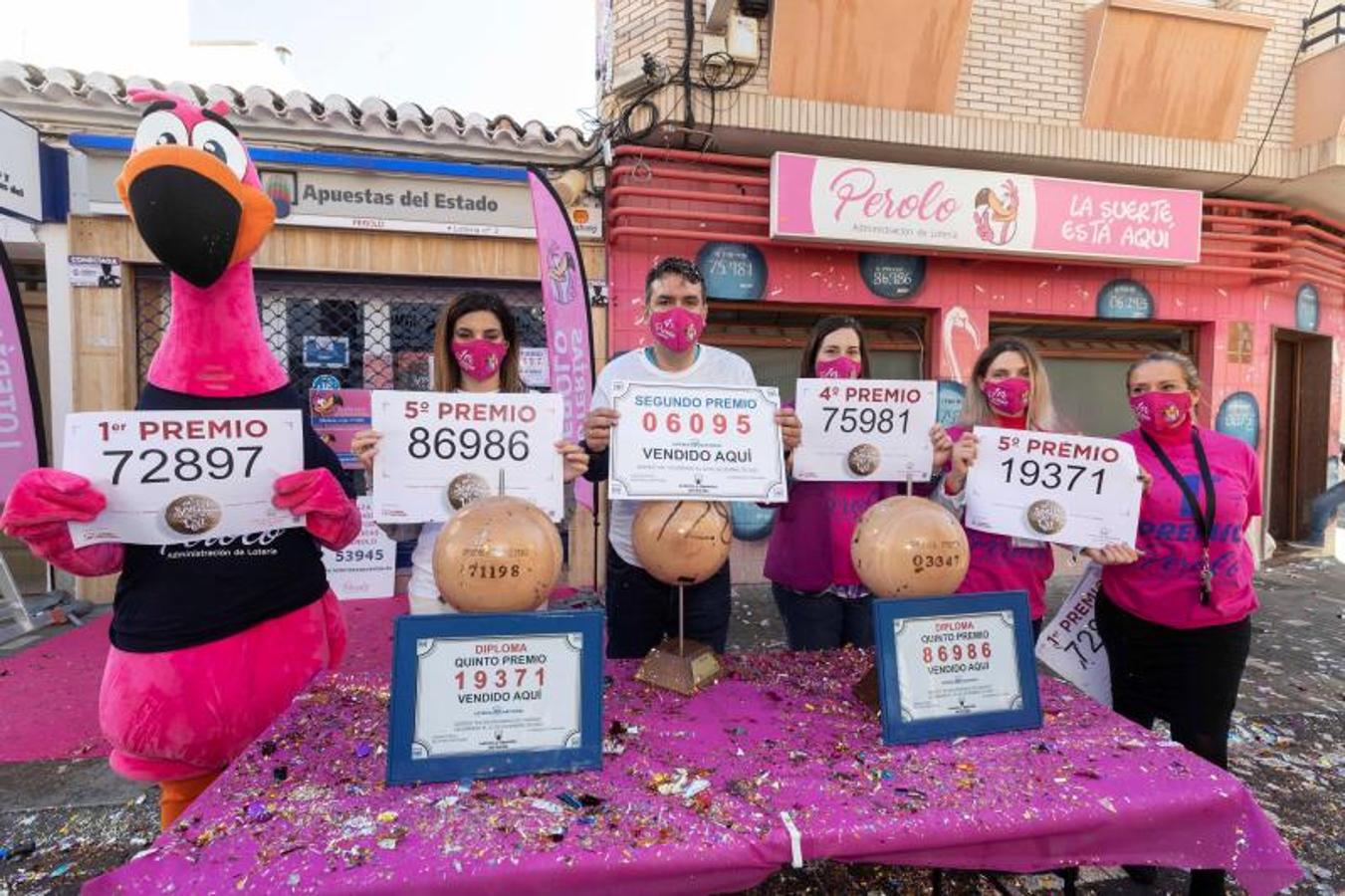 El gerente de la administración número 2 de lotería de San Pedro del Pinatar Miguel Ángel Zapata (centro) muestra junto a varias empleadas los cinco premios que han dado hoy en el sorteo de la lotería de Navidad, el gordo, el segundo, un cuarto y dos quintos.