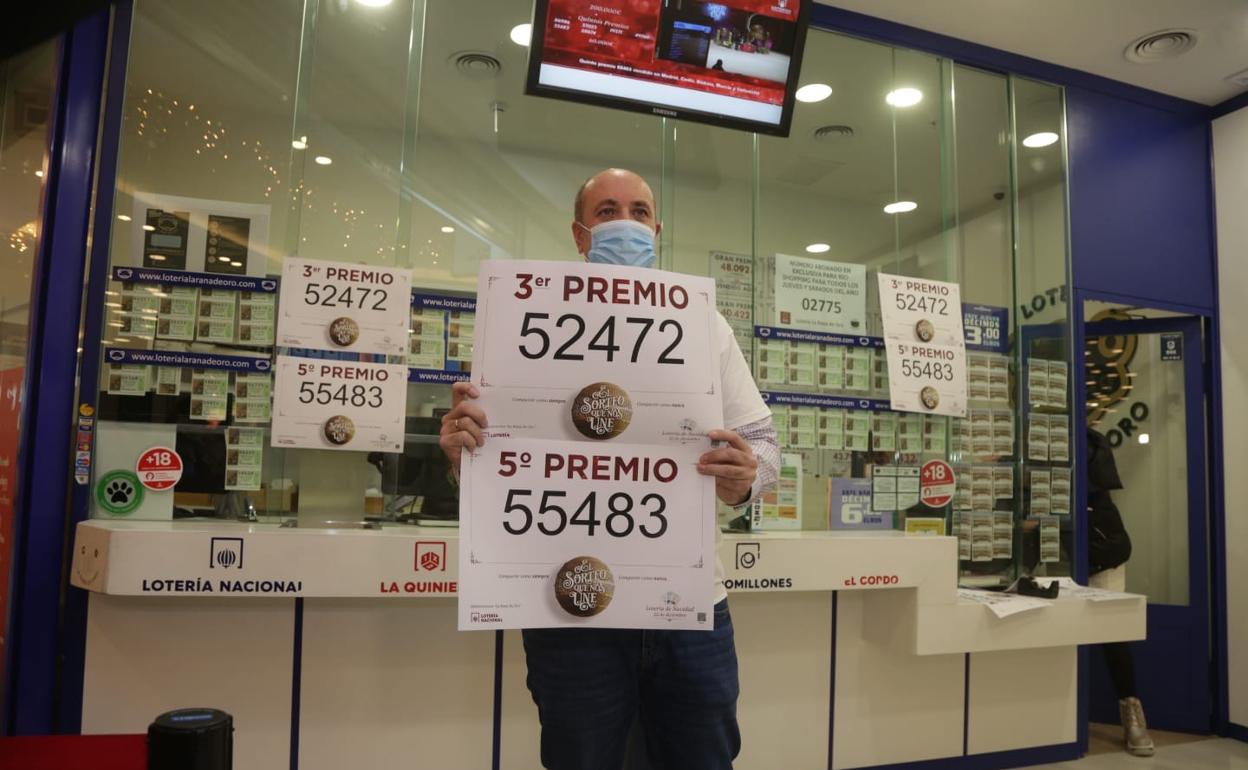 El responsable de la administración La Rana de Oro, Luis Vázquez, posa con los números agraciados en el sorteo extraordinario de la Lotería de Navidad. 