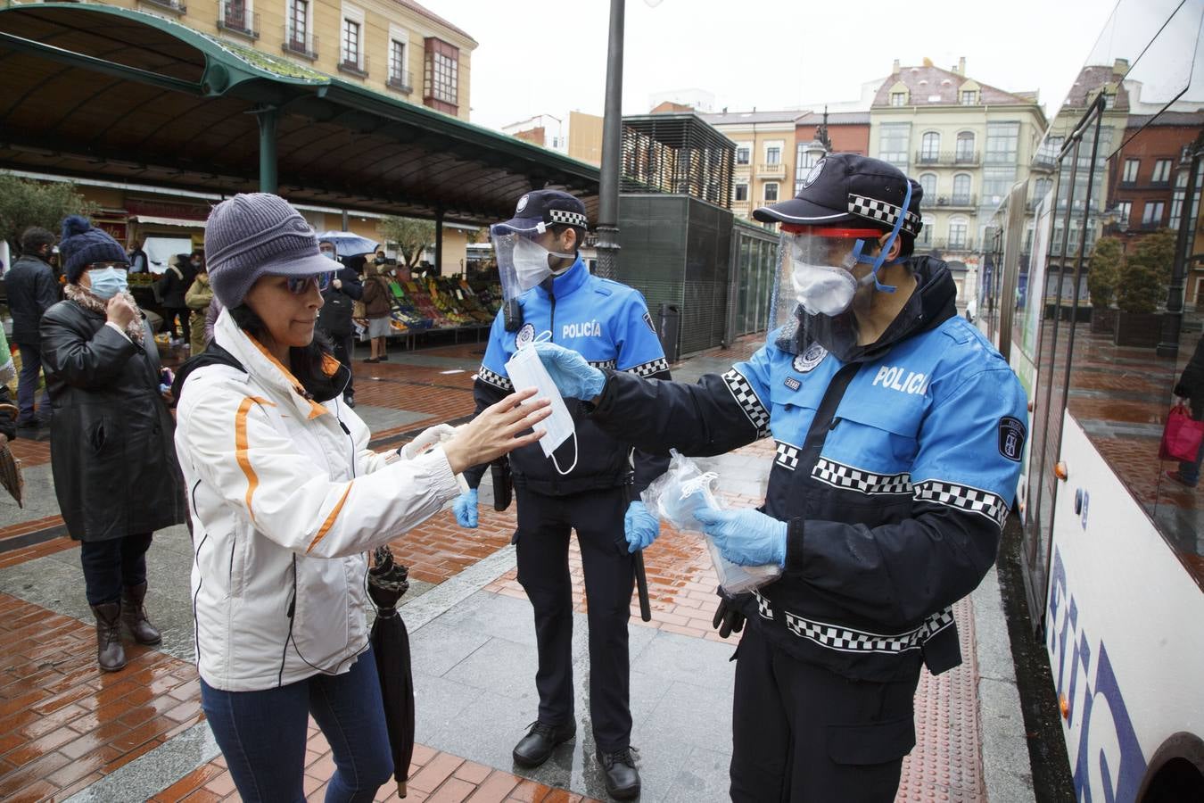 El uso obligatorio de la mascarilla obligó a los agentes de la autoridad a repartirlas los primeros días ante la escasez que hubo durante los primeros días. En la imagen la policía municipal reparte mascarillas a los ciudadanos en la Plaza de España.