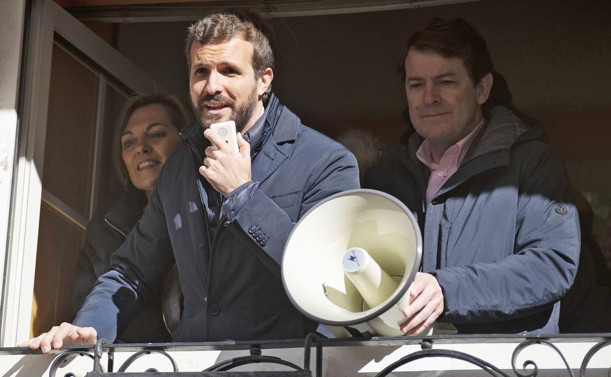 Mañueco sujeta el megáfono a Casado en un mitin en Palencia en noviembre de 2019, en una ventaja junto a Milagros Marcos.