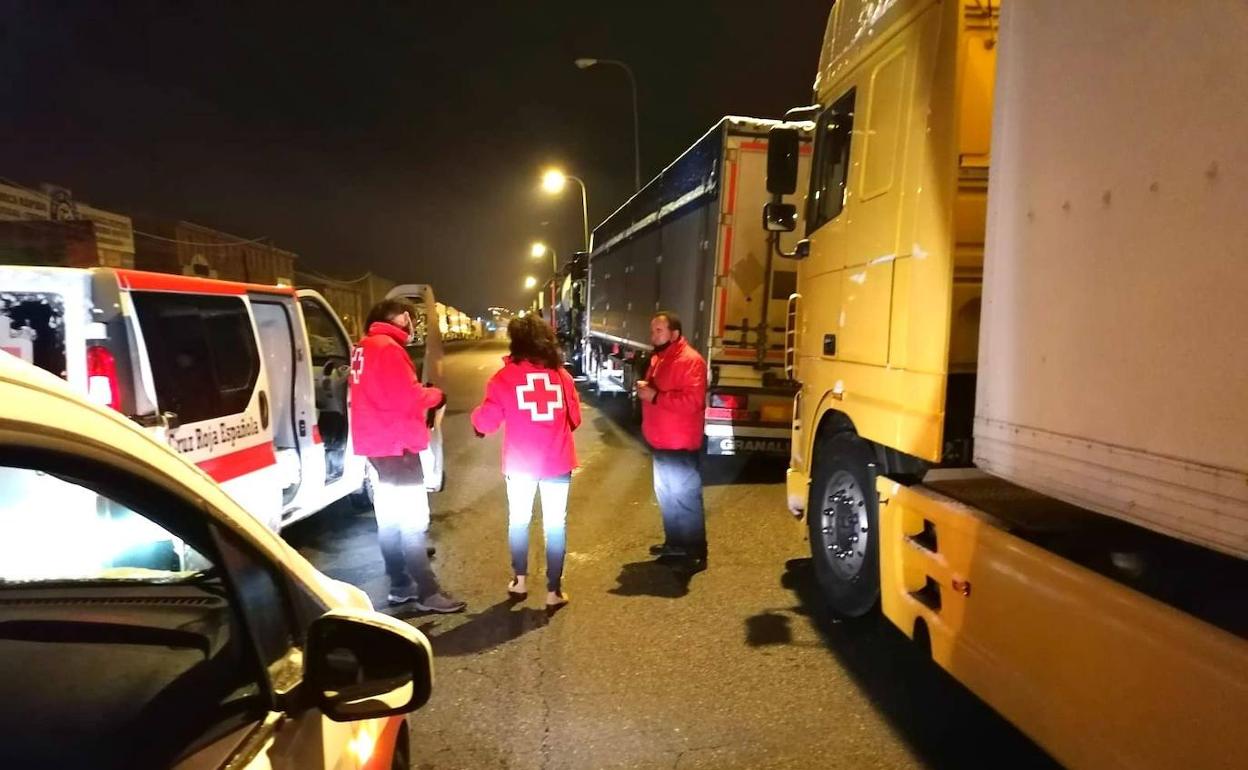 Voluntarios de Cruz Roja en Segovia, en la mdrigada de este sábado, atienden a camioneros en Hontoria. 