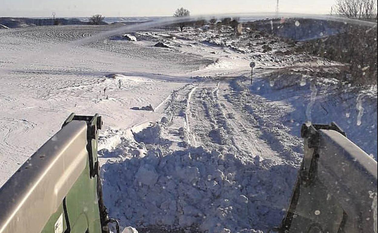 Un vecino despeja con su tractor la carretera de Piñel de Abajo a Catroverde a una bodega.