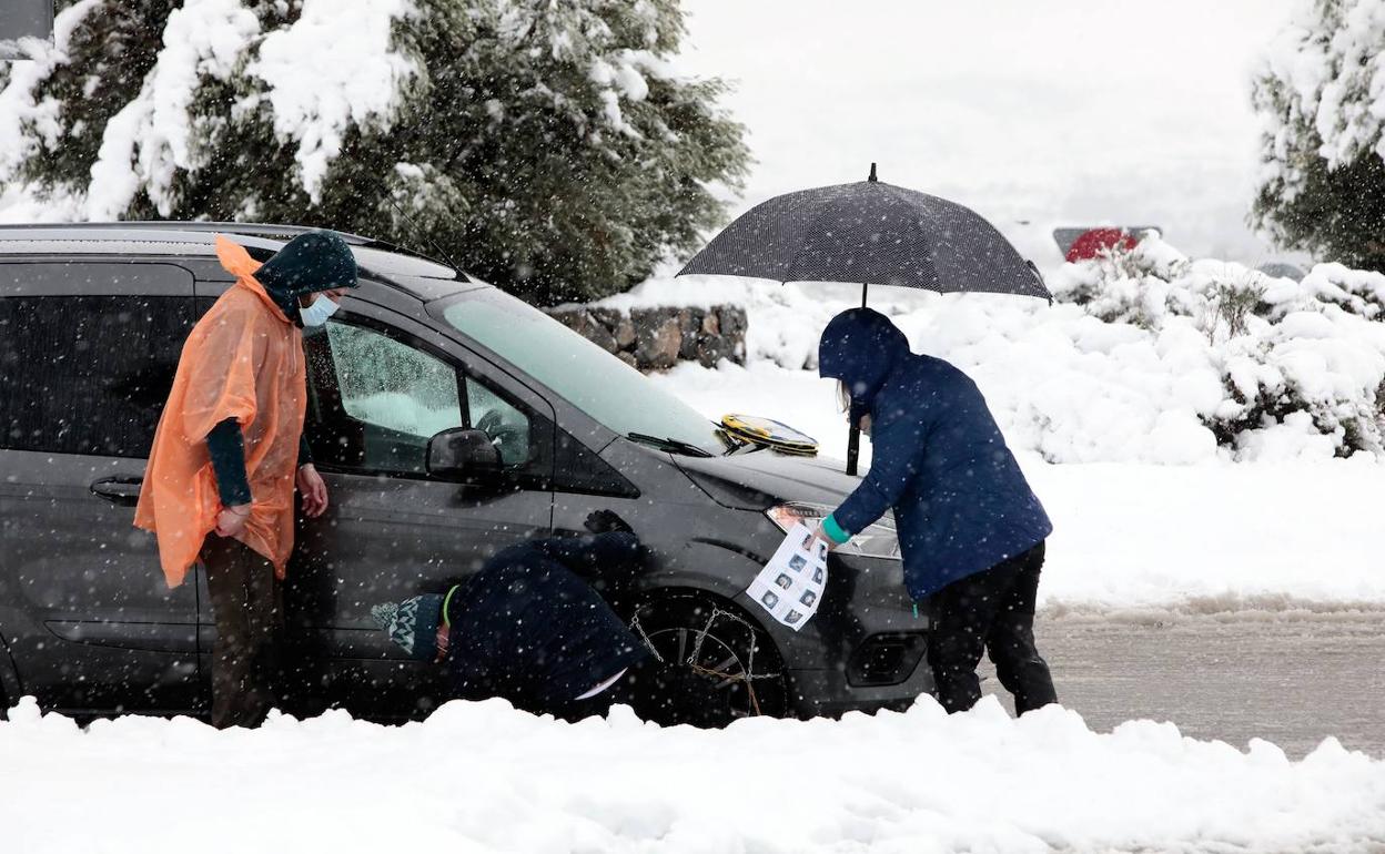 Varias personas intentar colocar las cadenas en la A-23, en Castellón.