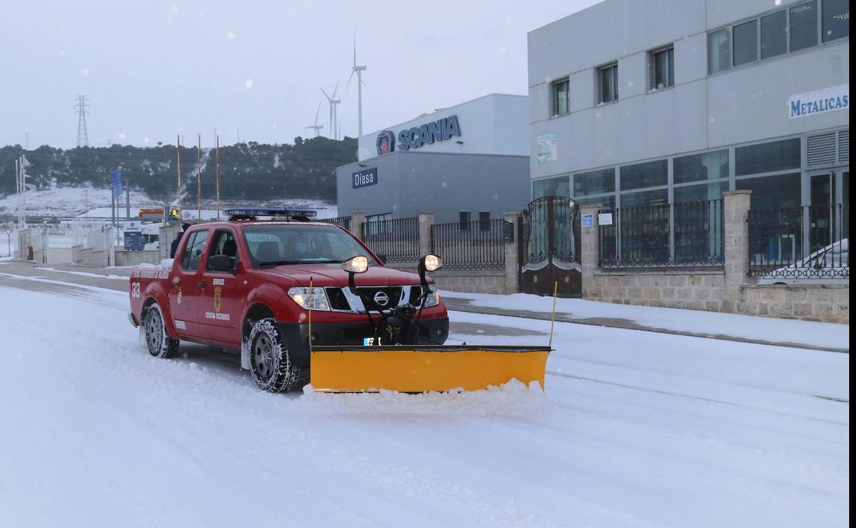 Los bomberos limpian calles del poligono industrial de Palencia.