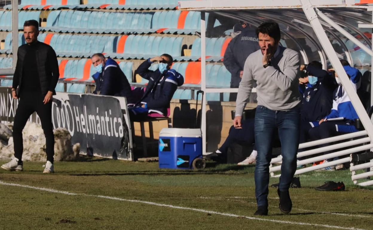 Escobar da instrucciones a sus jugadores y al fondo, Rubén de la Barrera. 